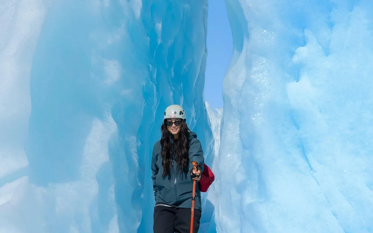 A hiker in supplied boots and crampons standing on the glacier