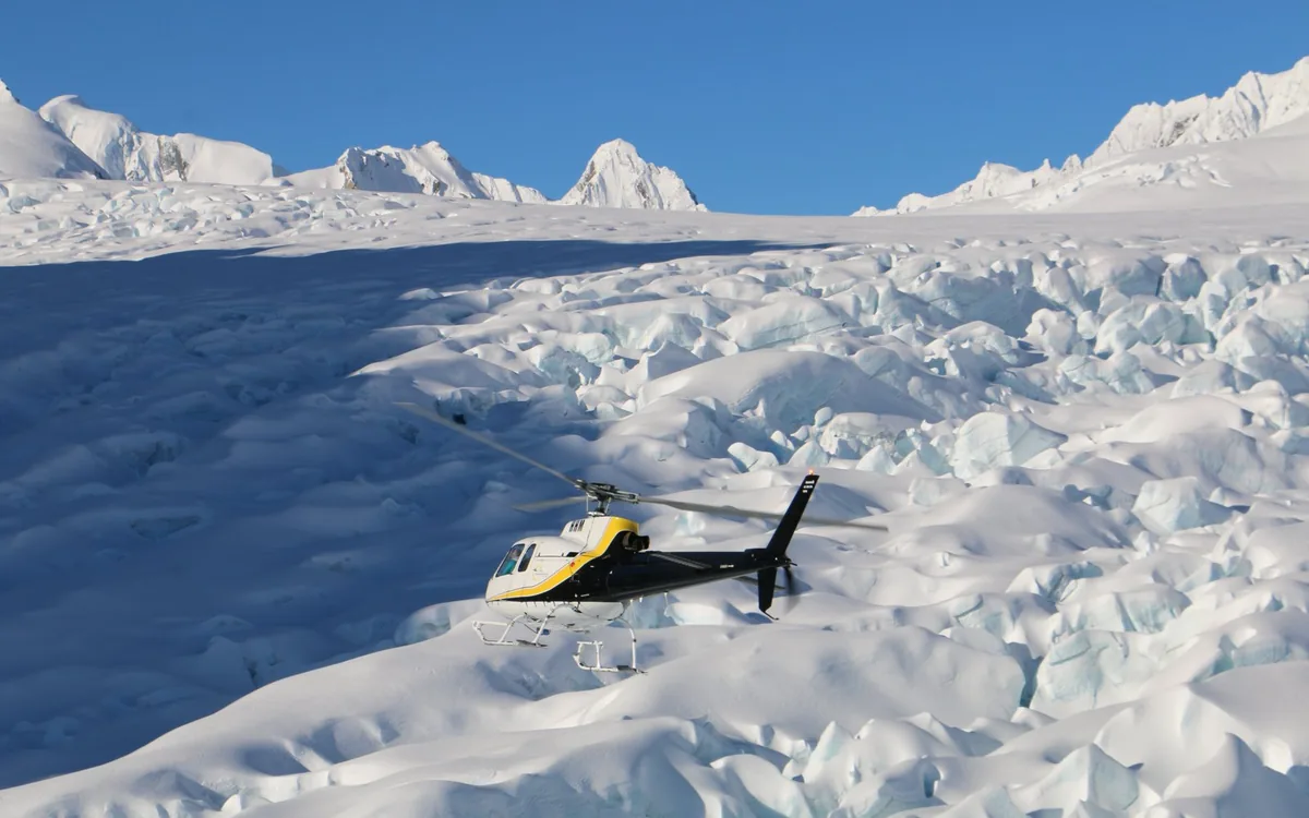 A helicopter shut down on the snowfield above Franz Josef Glacier